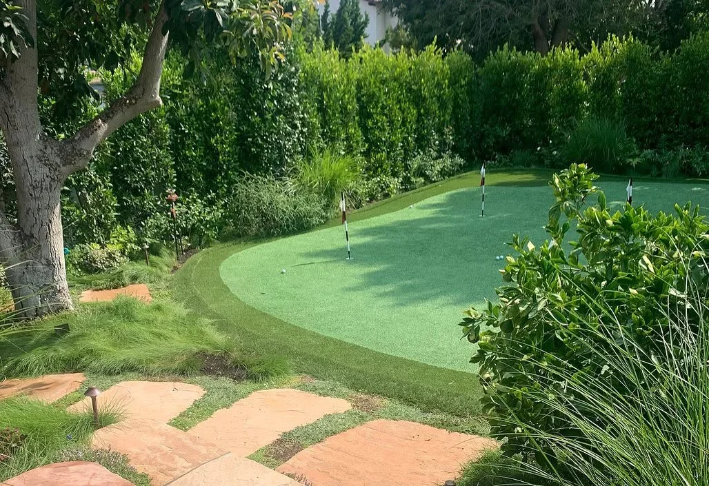 Backyard putting green with curved artificial turf installed by Chula Vista landscaping services.