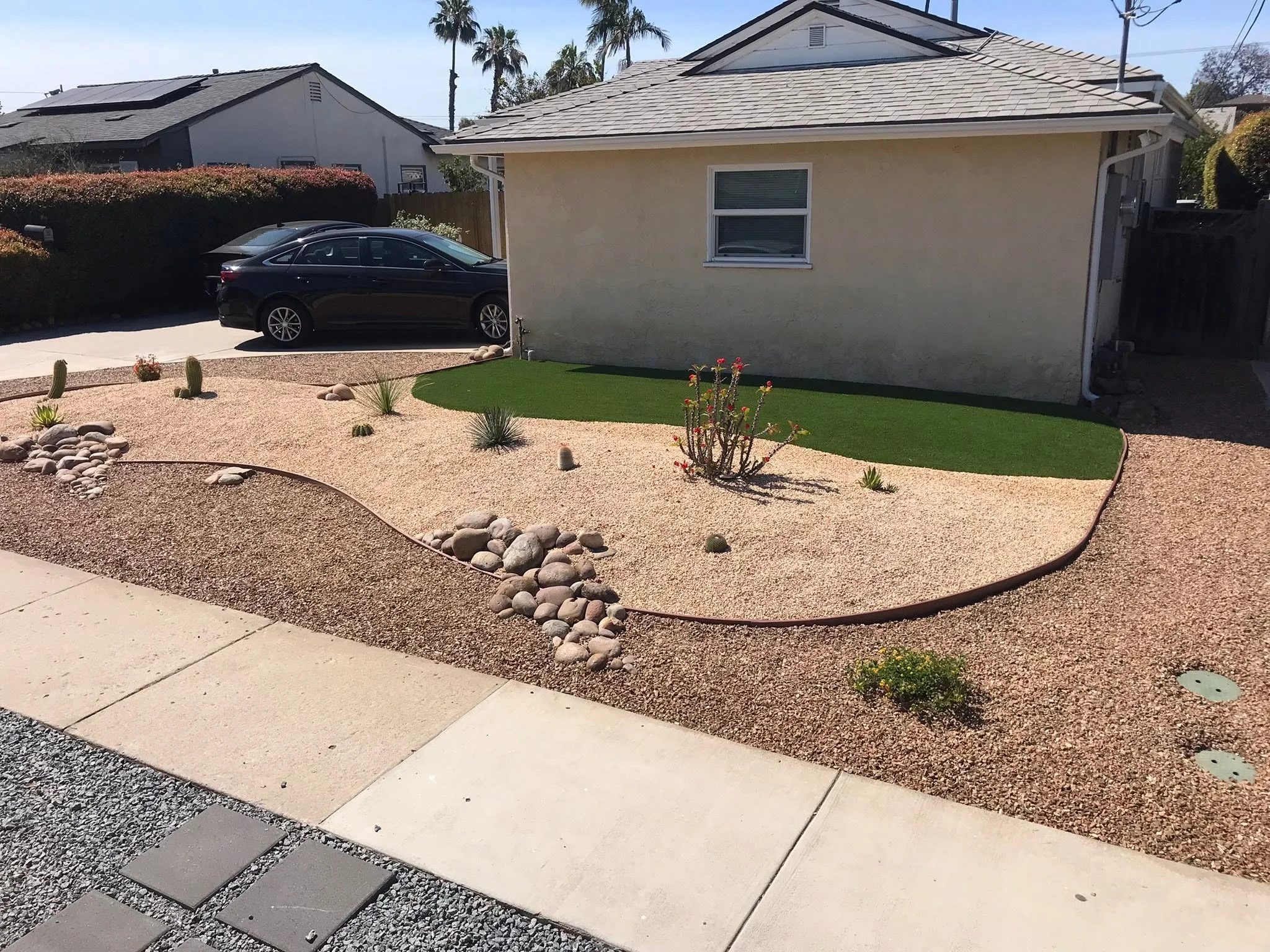 Drought tolerant rock yard with artificial turf accents for Chula Vista landscaping.