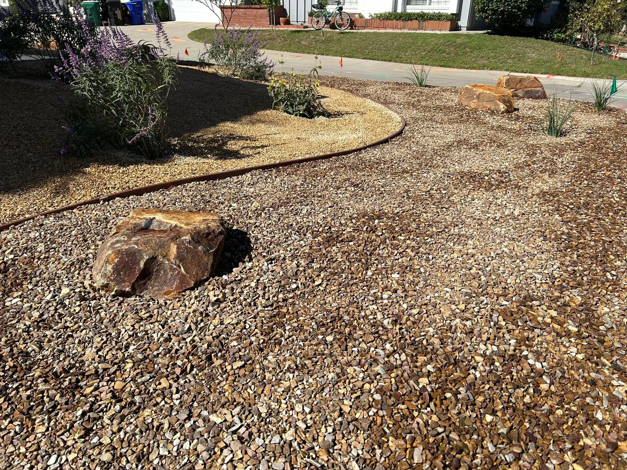 Dry creek rock border and gravel yard design for landscaping services in Chula Vista.